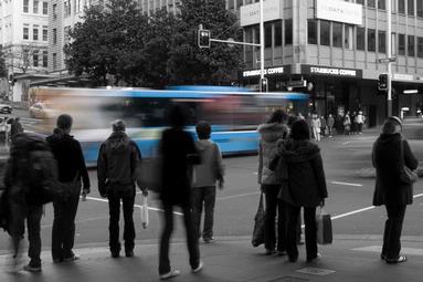 Long exposure to show a bus moving whilst pedestrians wait to cross a road